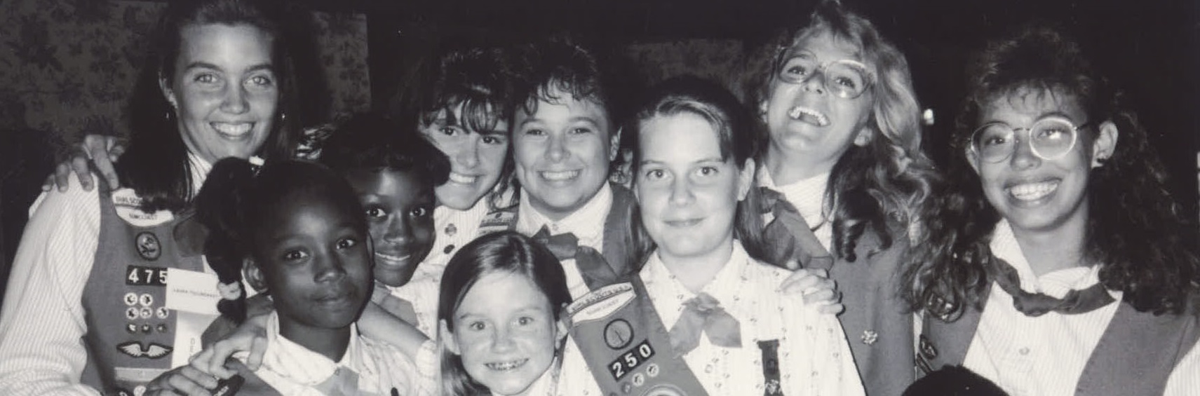  group of young girl scout alums smiling and talking to one another 