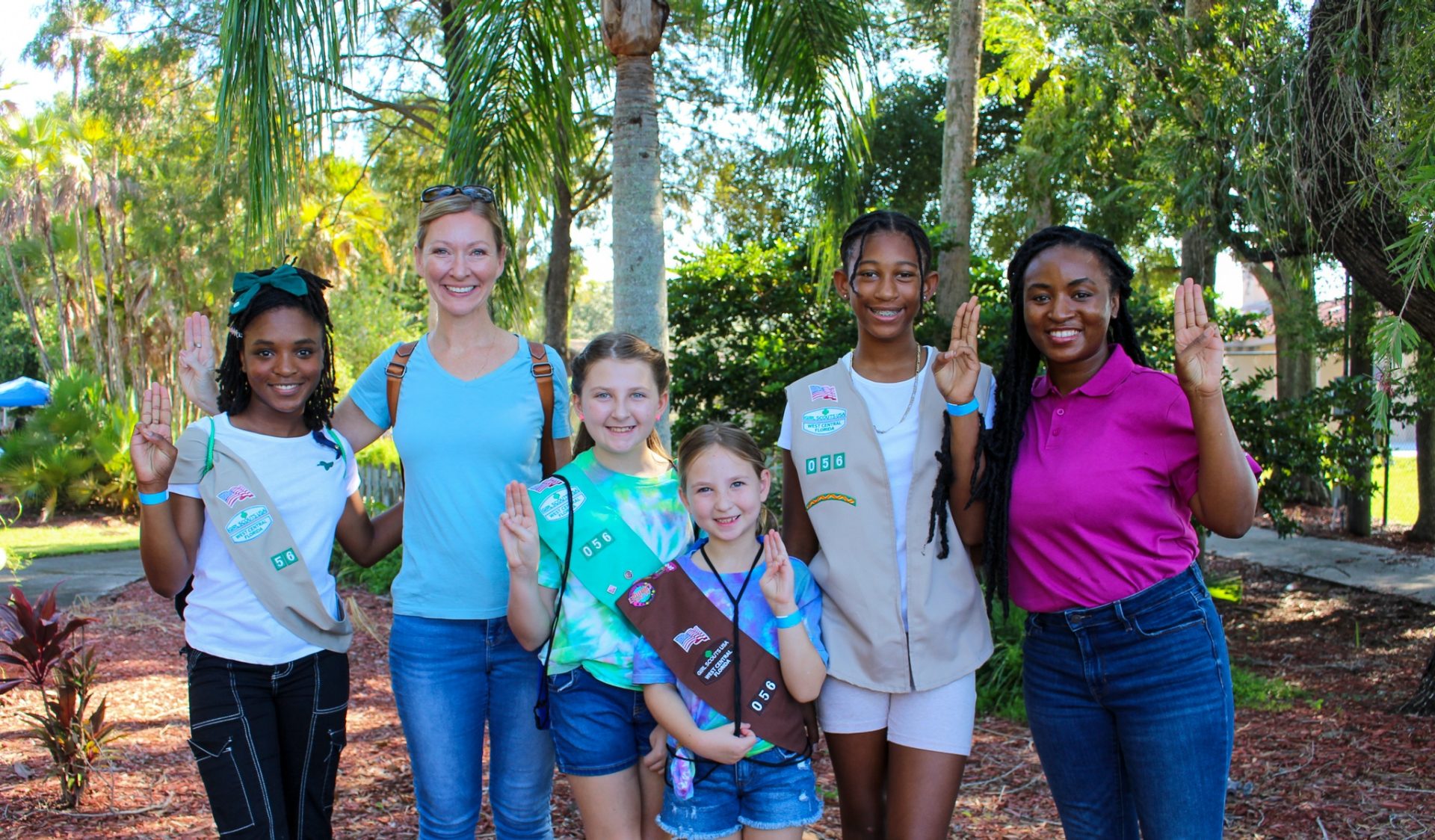  portrait of ambassador girl scout wearing vest and smiling at camera in front of a brick building 